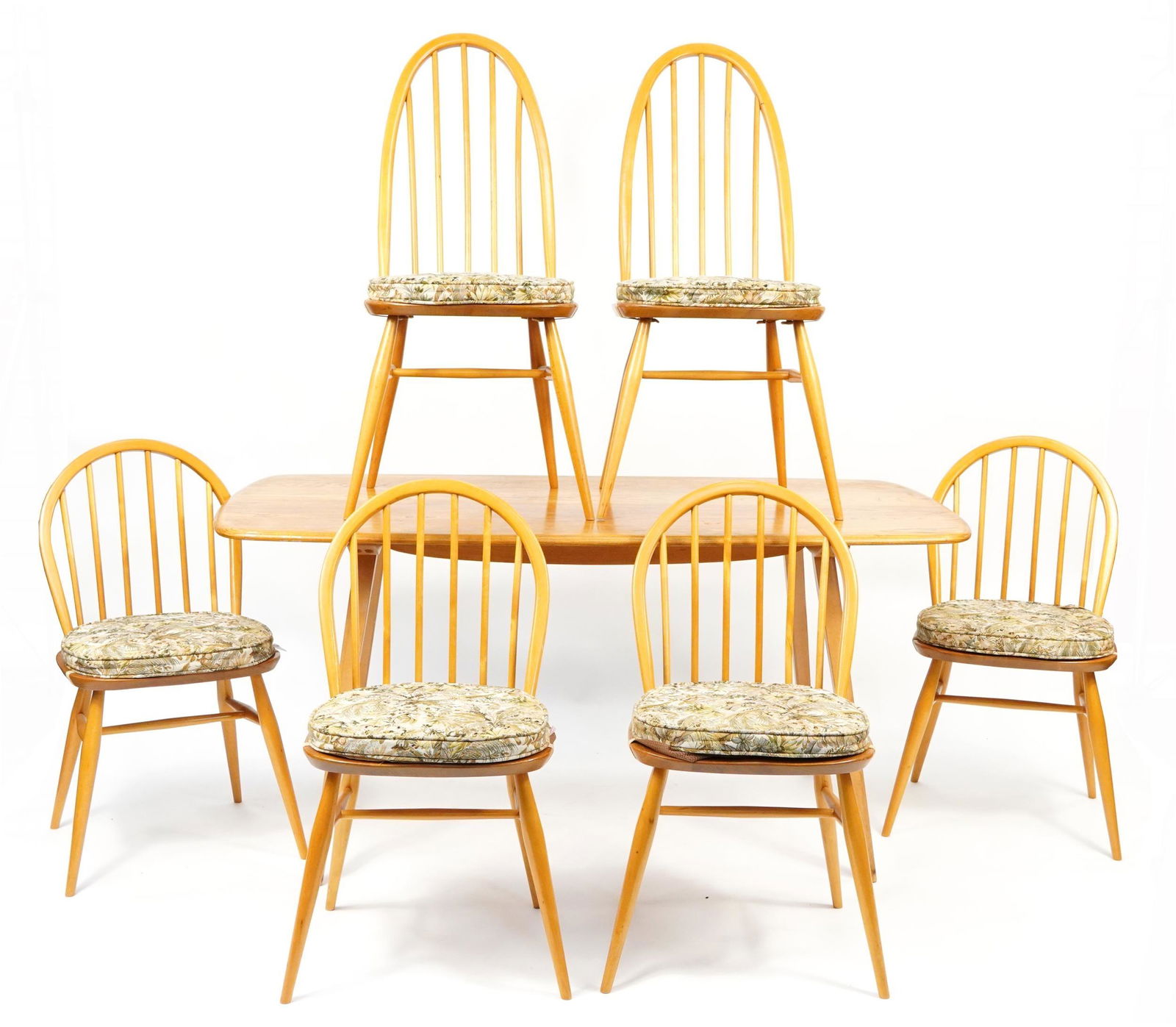 Ercol light elm plank dining table with set of six Windsor dining chairs having floral upholstered: Ercol light elm plank dining table with set of six Windsor dining chairs having floral upholstered cushioned seat covers, the dining table 72.5cm H x 152cm W x 72cm D, the largest chairs each 98cm hig