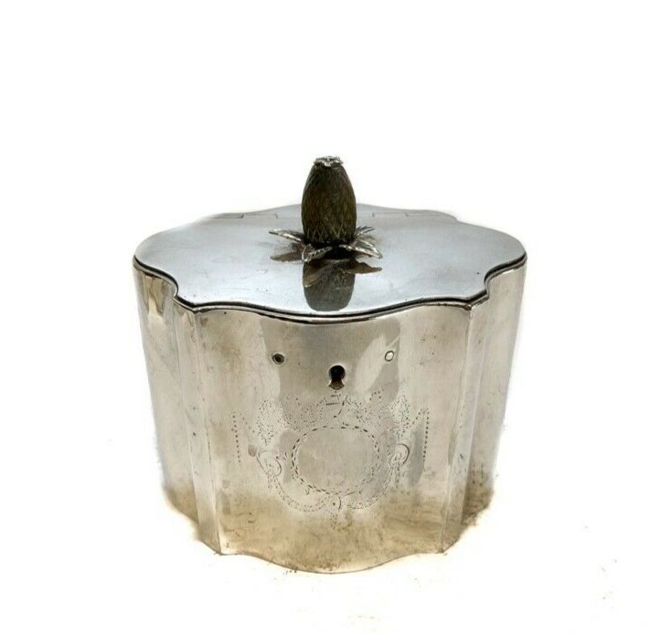 William Vincent George III English Sterling Silver Tea Caddy 1778 Bone Finial: George III London English sterling silver tea caddy by William Vincent, 1778. Hand engraved bone finial in the form of a pineapple or acorn. Lobed body with engraved crest to the front. Hinged top wit