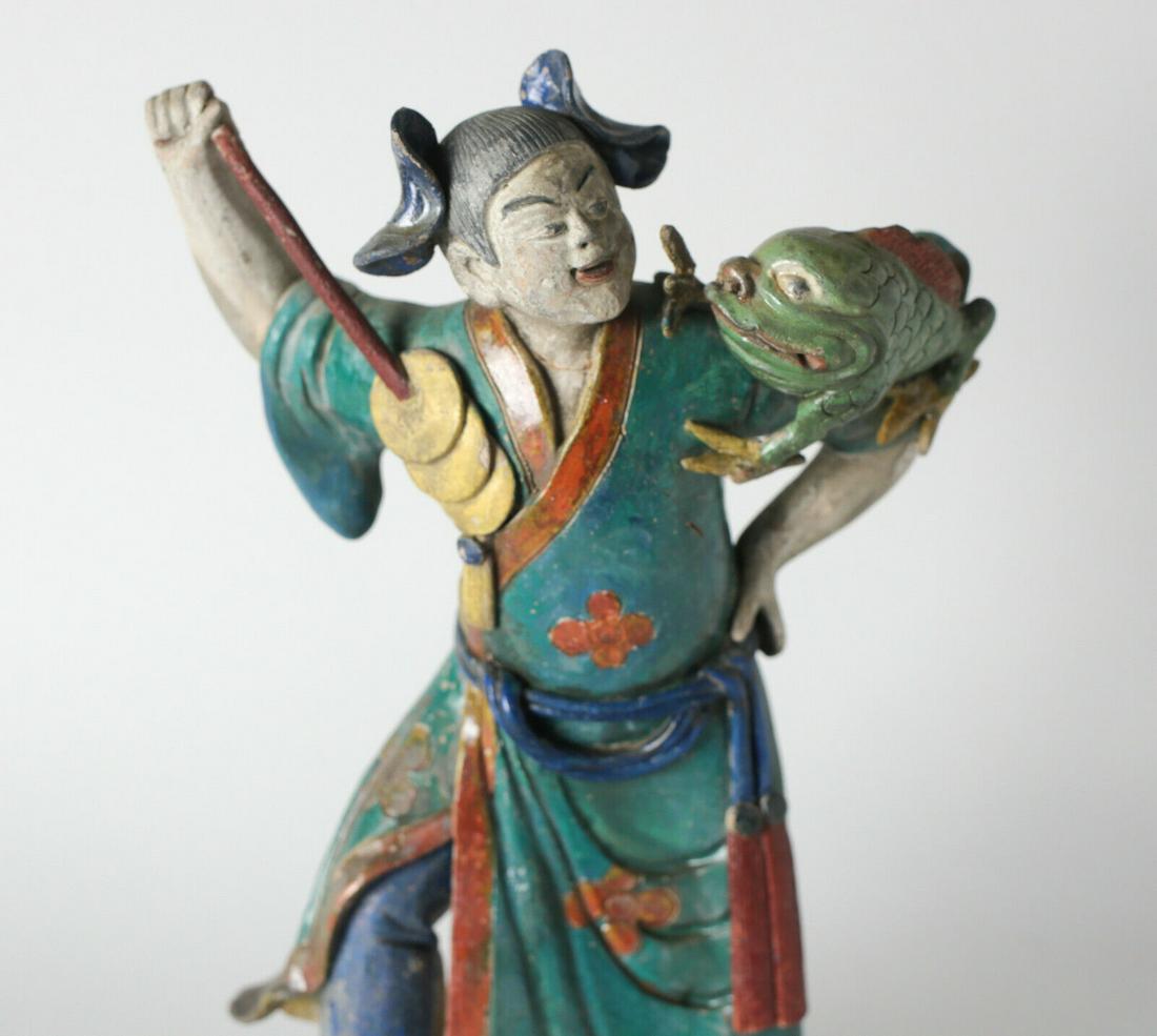 19th c Chinese Polychrome Stucco Roof Figure Liu Haichan with frog: 19th century Liu Haichan Chinese polychrome Stucco Roof Figure, the three-legged chanchu money toad on his shoulder, holding a string of coins. A Daoist 'immortal'. Mounted on an acrylic stand. 4lbs A