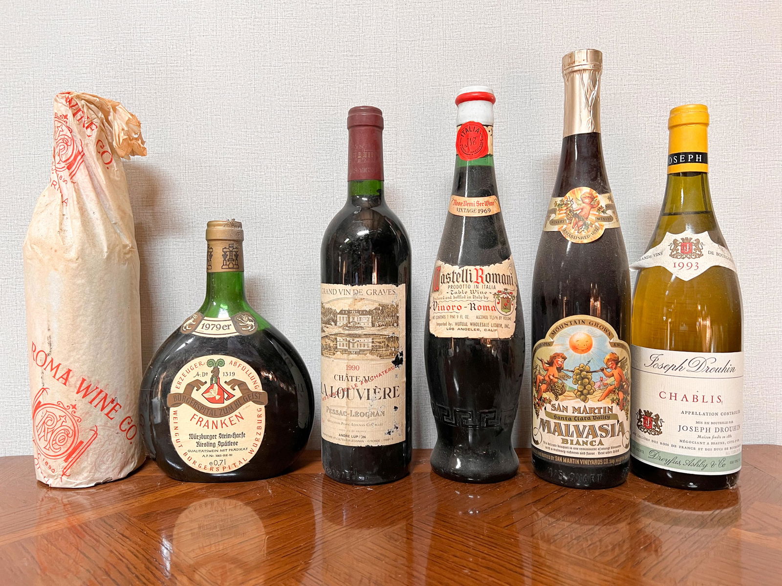 6 Vintage Estate Bottles of Wine Spirits Assorted: Roma Wine 1935 in wraps; Weingut Burgerspital Wurzburg Franken 1979; Grand Vin de Graves Chateau La Louviere 1990; Castelli Romani 1969; San Martin Malvasia; Joseph Drouhin 1993 Roma Wine 1935 in wrap