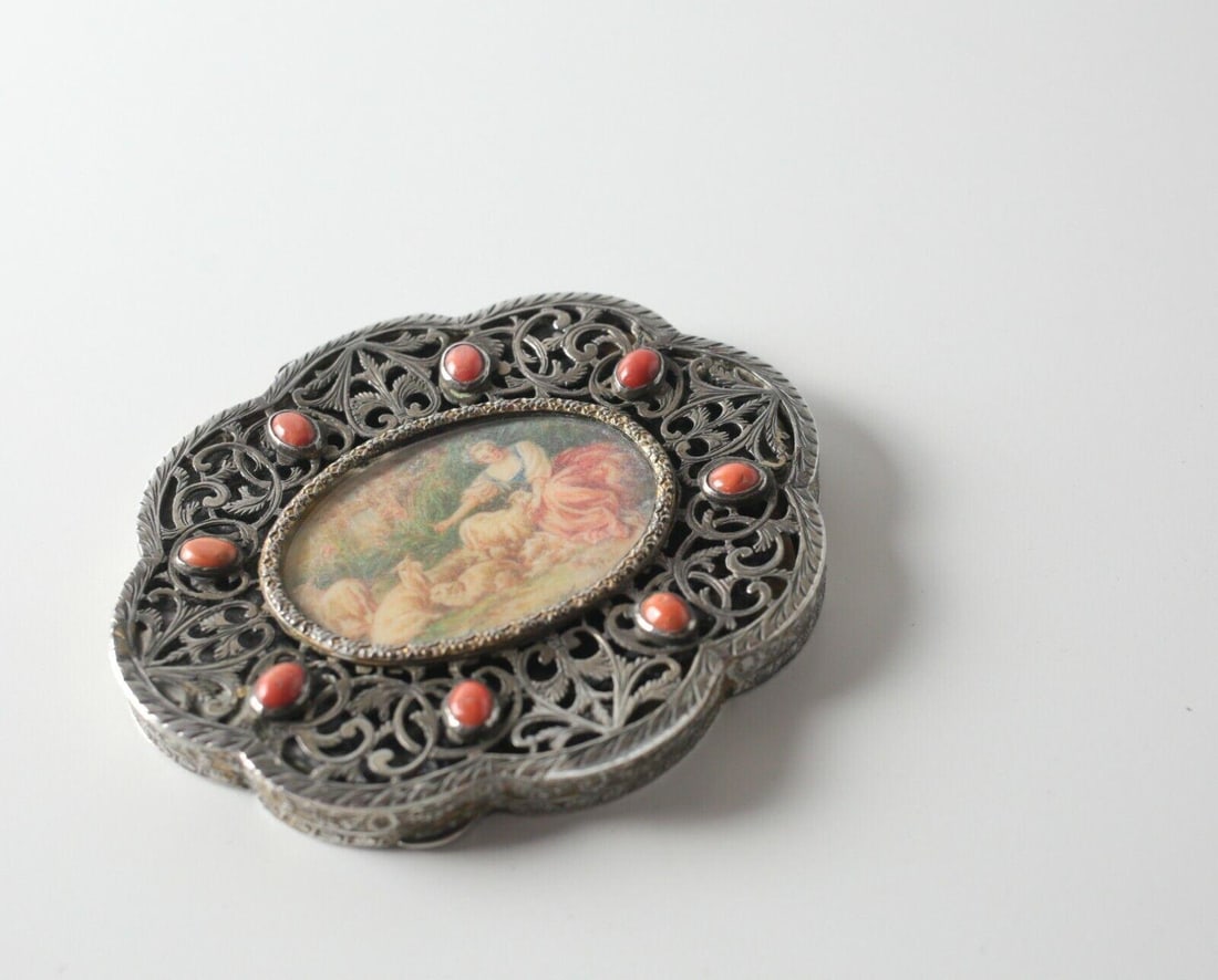 Italian Gilt Reticulated 800 Silver compact with miniature scene, c1920: An Italian Gilt 800 Silver compact with miniature scene, c1920, engraved reticulated leaf scrolls, 8 coral cabochons, and tortoise shell lining. Hand painted scene of young woman and sheep, painting m