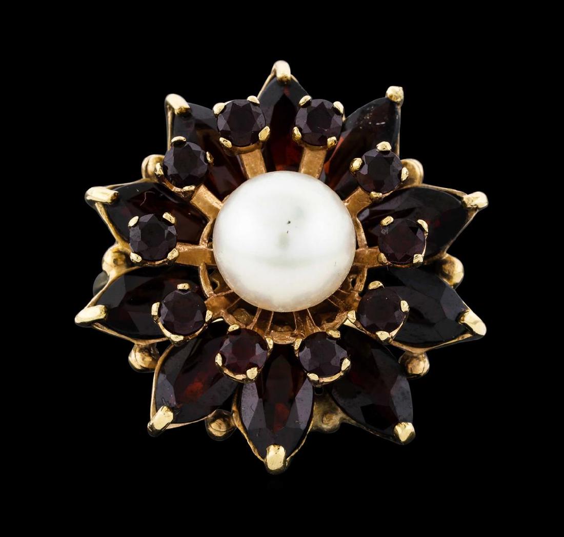 14KT Yellow Gold 7.7mm Pearl and Pyrope Garnet Ring: One electronically tested 14KT yellow gold lady's cast fashion ring with a split shank basket halo with a bright polish finish. The featured lady's ring has a shank measuring 2.00 millimeters wide. Tr