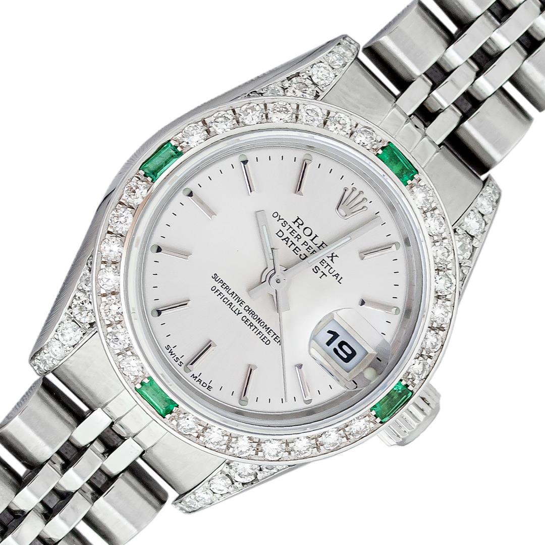 Rolex Ladies Stainless Steel Silver Index Emerald and Diamond Datejust Wristwatch: One Ladies Pre Owned Quickset Stainless Steel Rolex Datejust Polished Bright with Satin Finish, Serviced & Electronically Tested, Stainless Steel Case: 26mm, Custom Diamond Lugs: Added Diamonds On Lug