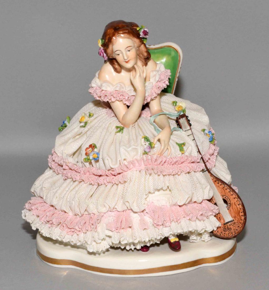 VOLKSTEDT DRESDEN LACE BONE CHINA PORCELAIN LADY: VOLKSTEDT DRESDEN LACE BONE CHINA PORCELAIN LADY FIGURINE SITTING W/MANDOLIN INSTRUMENT. Blue crown mark. Condition: several broken pieces of porcelain lace and flowers. 8''h x 7''w.