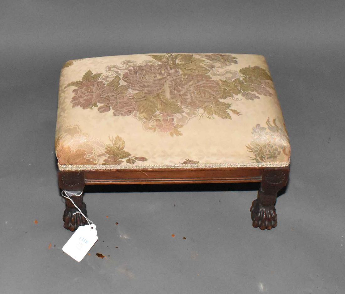 A SMALL MAHOGANY-FRAMED FOOTSTOOL, upholstered in: A SMALL MAHOGANY-FRAMED FOOTSTOOL, upholstered in machine-made silk tapestry, on carved paw feet. 9 in. high; 16 in. wide; 10 in. deep.