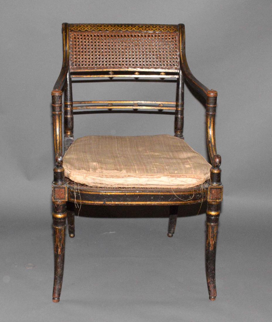 A REGENCY PAINTED AND CANED ARMCHAIR. Circa 1820. 33: A REGENCY PAINTED AND CANED ARMCHAIR. Circa 1820. 33 1/2 in. high; 21 1/4 in. wide; 20 in. deep.
