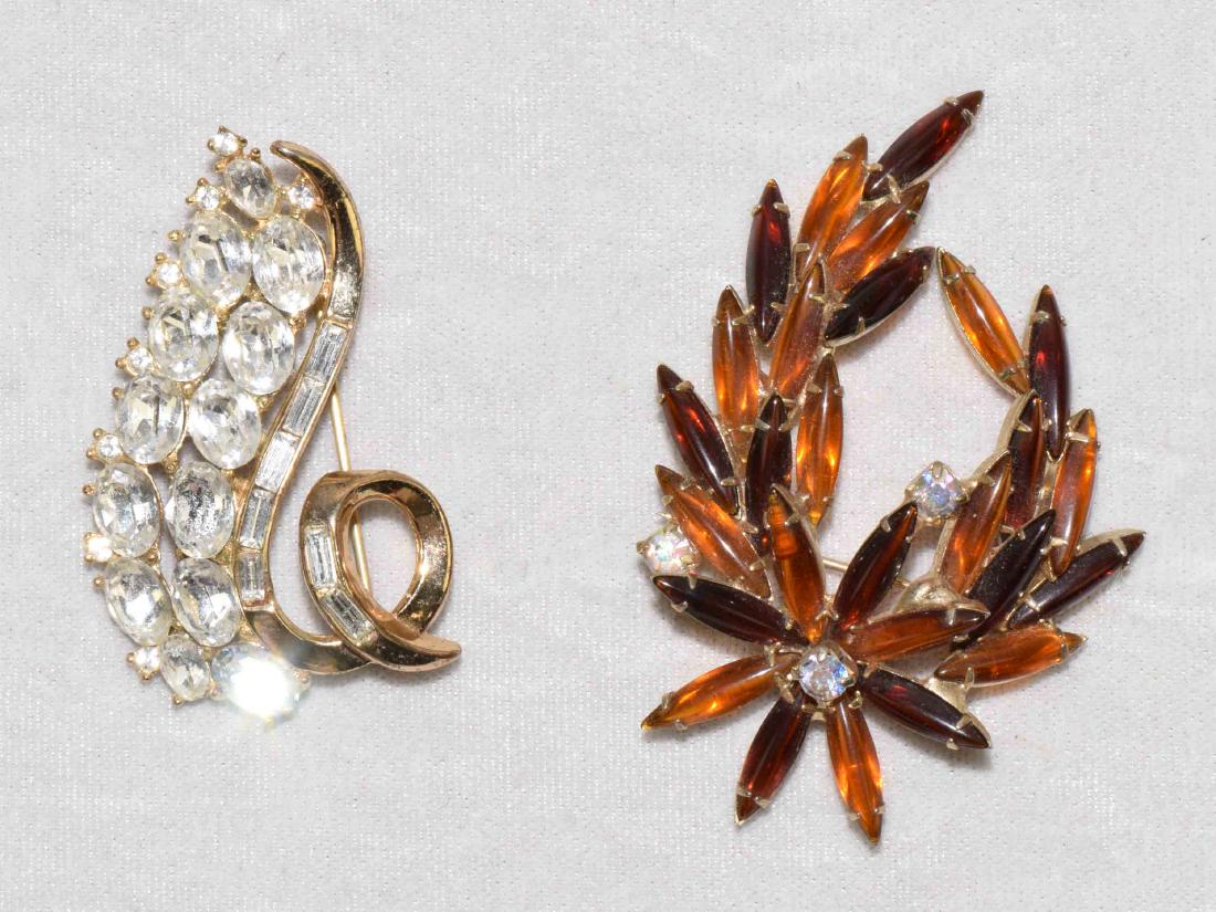 (2) ASST. VINTAGE GOLDTONE BROOCHES: Trifari pat.: (2) ASST. VINTAGE GOLDTONE BROOCHES: Trifari pat. pending swirl of rhinestones and a faux amber cabachon Juliana style, unsigned.