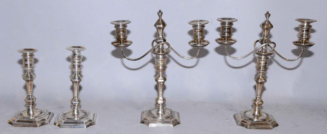 AN ASSEMBLED SET OF FOUR AMERICAN STERLING: AN ASSEMBLED SET OF FOUR AMERICAN STERLING CANDLESTICKS, in George II/III style, 20th century. Including: a pair, by Roby, on a shaped square base, 7 3/4 in. high (each); total height including candle
