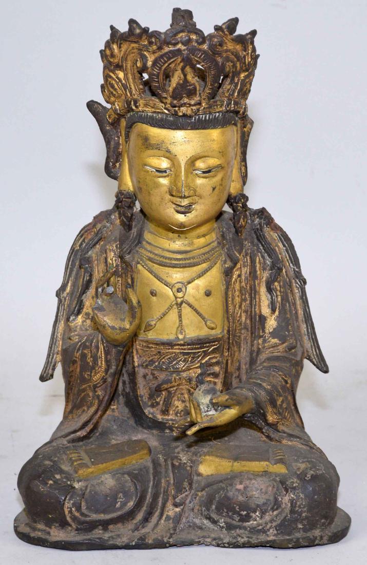 A CHINESE GILT-BRONZE FIGURE OF A SEATED BUDDHA. Ming: A CHINESE GILT-BRONZE FIGURE OF A SEATED BUDDHA. Ming Dynasty or later. Holding a flaming pearl in his left hand. 10 3/4 in. high; 7 1/2 in. wide; 5 3/4 in. deep.