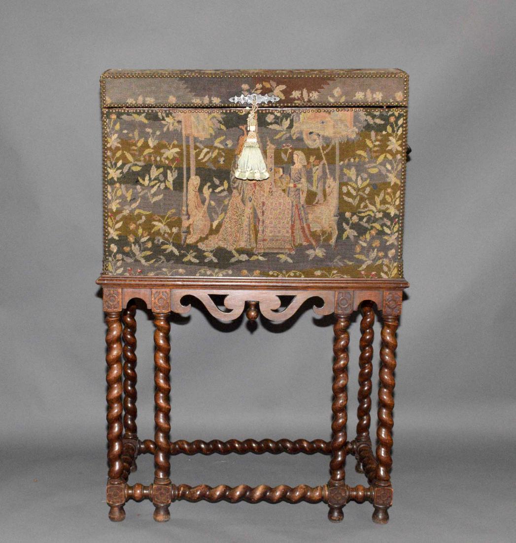 ANTIQUE TAPESTRY TRUNK/COFFER, on wooden table stand.: ANTIQUE TAPESTRY TRUNK/COFFER, on wooden table stand. Trunk - 23''H x 33''W x 18''D. Table stand - 30''H x 32''W x 22.5''D.