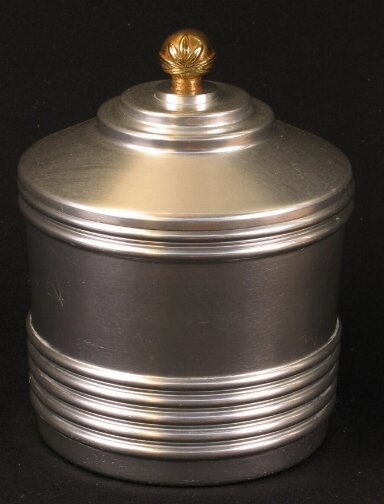 KENSINGTON WARE SNACK CRACKER JAR. 1934-1935. Art: KENSINGTON WARE SNACK CRACKER JAR. 1934-1935. Art Deco aluminum and brass ''Snack Cracker Jar'' cat. no. 7420. Designed by Lurelle Guild, patent applied for Oct. 11, 1934, patent issued Jan. 1, 1935.