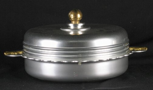 KENSINGTON WARE HYDE PARK DISH. Art Deco aluminum: KENSINGTON WARE HYDE PARK DISH. Art Deco aluminum and brass ''Hyde Park Covered Serving Dish'' cat. no. 7380. Designed by Lurelle Guild. Marked: stag head, shield and script mark. Size: 5''H, 13 1/4''