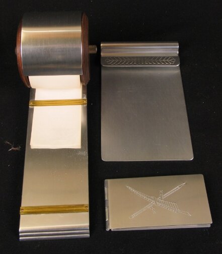3 KENSINGTON DESK ITEMS. Three Art Deco aluminum: 3 KENSINGTON DESK ITEMS. Three Art Deco aluminum Kensington Ware desk items. (1) Oxford Memo Roll Cat. no. 7013. Designed by Lurelle Guild 1939-1940. Marked: stag head, shield and script mark. Conditi