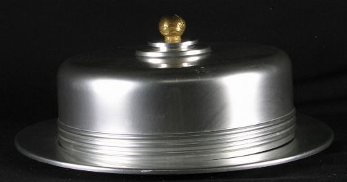 KENSINGTON YORKSHIRE CAKE TRAY: KENSINGTON YORKSHIRE CAKE TRAY. Art Deco aluminum and brass "Yorkshire covered cake tray" cat. no. 7103. Designed by Lurelle Guild. Aluminum base, no round wooden insert, aluminum dome with brass knob