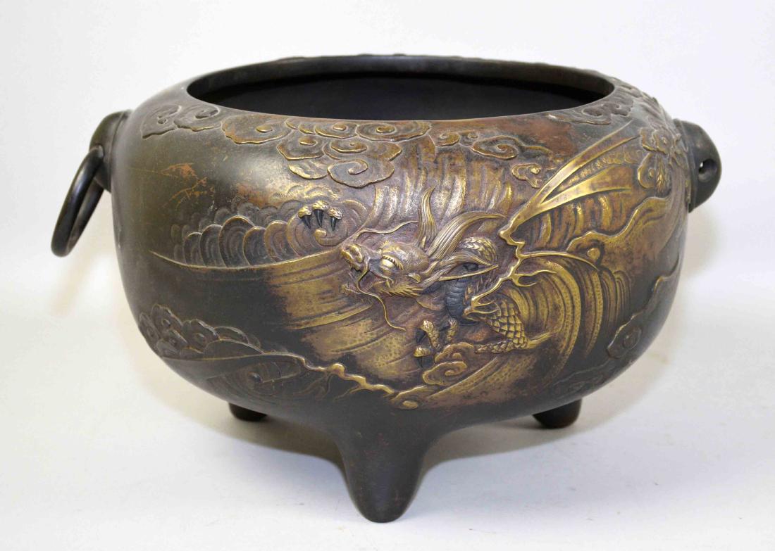 JAPANESE ANTIQUE BRONZE (3) LEGGED URN. Missing one: JAPANESE ANTIQUE BRONZE (3) LEGGED URN. Missing one ring and dent to side. Signed in character mark.