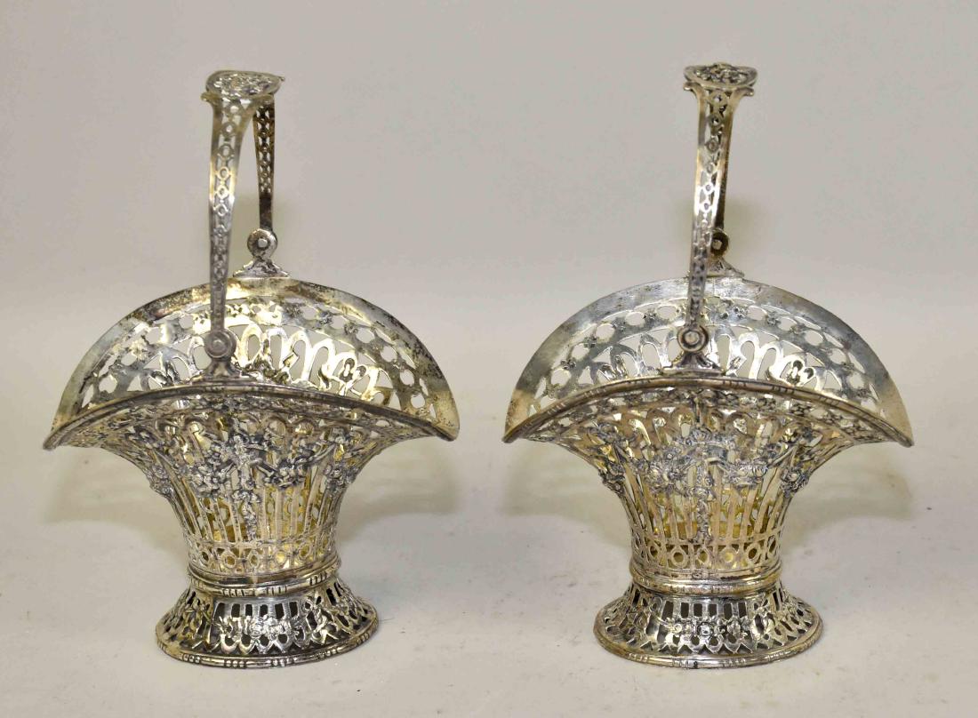 (2) SILVER BASKETS. Asssembled pair. Each w/swing: (2) SILVER BASKETS. Asssembled pair. Each w/swing handles and pierced baskets w/floral garlands and baskets of garden tools on oval bases. One hallmarked Nuremberg & sterling, the other unmarked. 5''