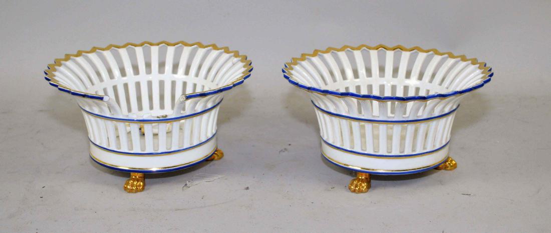 TWO PARIS-STYLE WHITE AND GILT-FENESTRATED BEAKER-FORM: TWO PARIS-STYLE WHITE AND GILT-FENESTRATED BEAKER-FORM BASKETS ON PAW FEET. Condition: one with rim breaks.