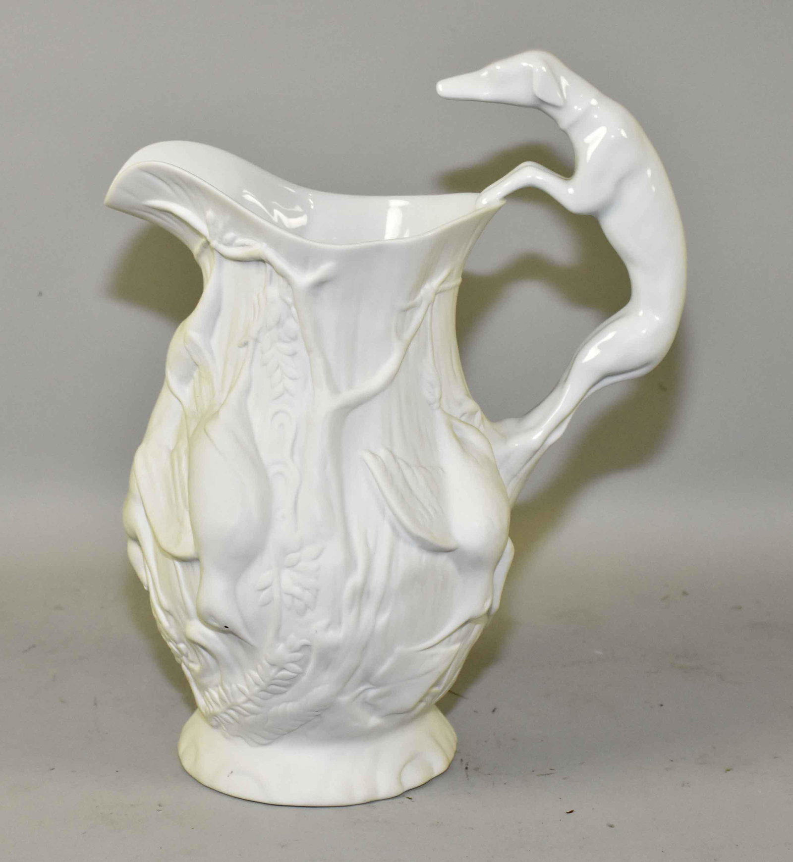 WHITE PORCELAIN DOG HANDLED HUNTING PITCHER. Vista: WHITE PORCELAIN DOG HANDLED HUNTING PITCHER. Vista Alegre, Portugal. 11.5''H. Estate of Stephen Totter.