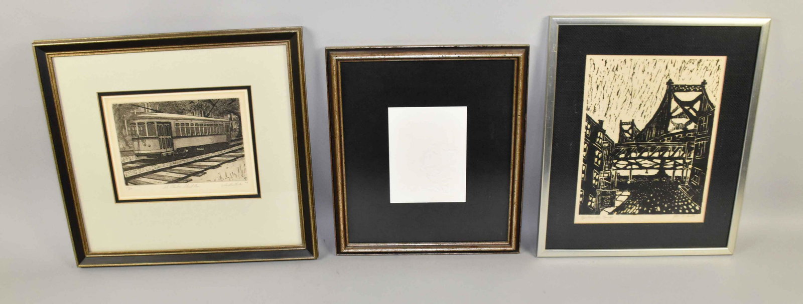 COLLECTION OF (3) ARTWORKS, etching by Leo Bautista (b.: COLLECTION OF (3) ARTWORKS, etching by Leo Bautista (b. 1952) ''St. Charles Street Car'', woodblock of Ben Franklin Bridge and cherub embossing. Estate of Stephen Totter. Largest frame: 15''H x 16''W.