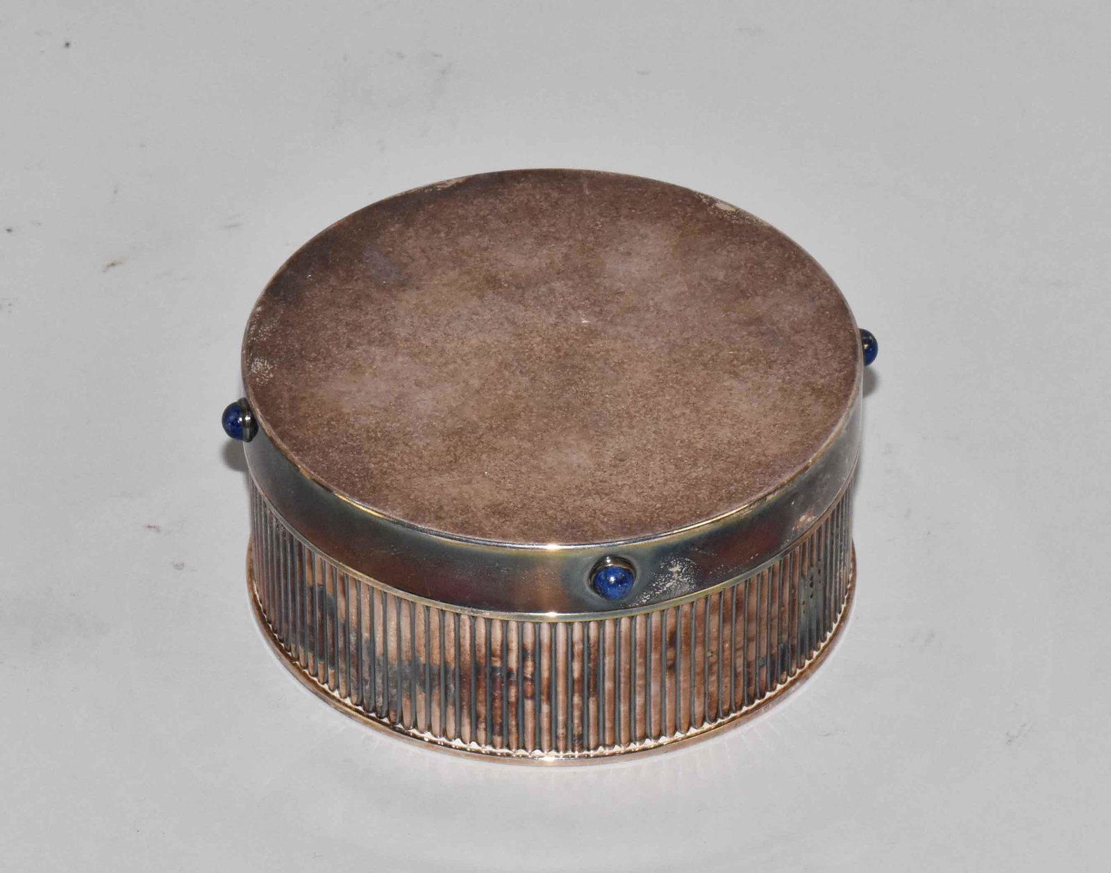 CARTIER ROUND SILVERPLATE COVERED TRINKET BOX, w/four: CARTIER ROUND SILVERPLATE COVERED TRINKET BOX, w/four Lapis cabachons. Mark - Spain. Good condition. Has tarnish and some surface scratches. 1 7/8''H x 4 5/8'' diameter. Estate of Stephen Totter.