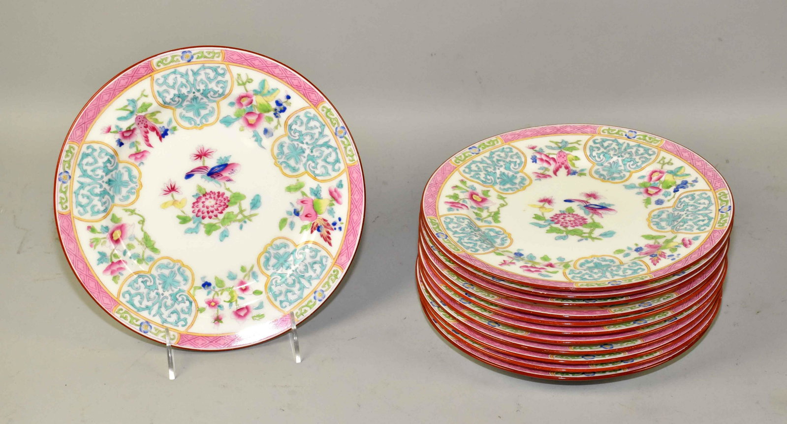 (12) VINTAGE MINTON CHINA SALAD PLATES, in pink: (12) VINTAGE MINTON CHINA SALAD PLATES, in pink turquoise w/floral and butterfly motif, c1859. W/red stamp, a4850 - 8.75'' diameter. One plate cracked. Estate of Stephen Totter.