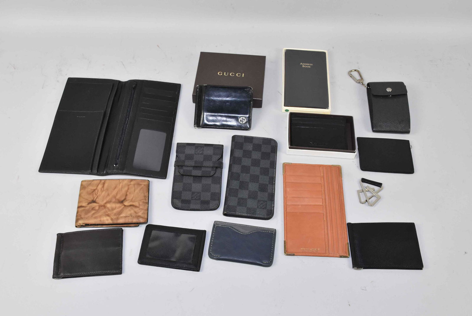 COLLECTION OF DESIGNER WALLETS, CASES, ETC., including: COLLECTION OF DESIGNER WALLETS, CASES, ETC., including Gucci, Pierre Cardin, Louis Vuitton, and Perry Ellis. Largest: 9''L x 4.5''W. Condition: mostly used. Estate of Stephen Totter.