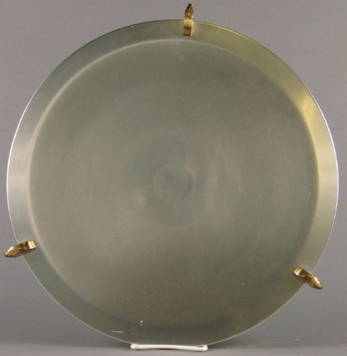KENSINGTON AZTEC FOOTED PLATTE: KENSINGTON AZTEC FOOTED PLATTER. Art Deco aluminum and brass Kensington Ware Aztec Footed Platter, designed by Lurelle Guild in 1938. Late mark: stag head, shield and script mark. Size: 16''Diam. Cond