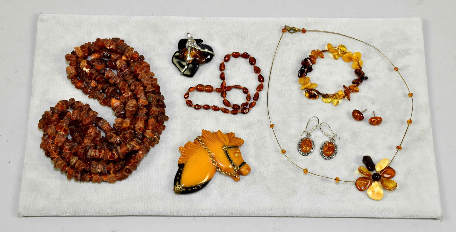 (8) MISC. PCS. OF AMBER COSTUME JEWELRY. To include:: (8) MISC. PCS. OF AMBER COSTUME JEWELRY. To include: necklaces pendant, earrings and bracelets. With a bakelite horse brooch.