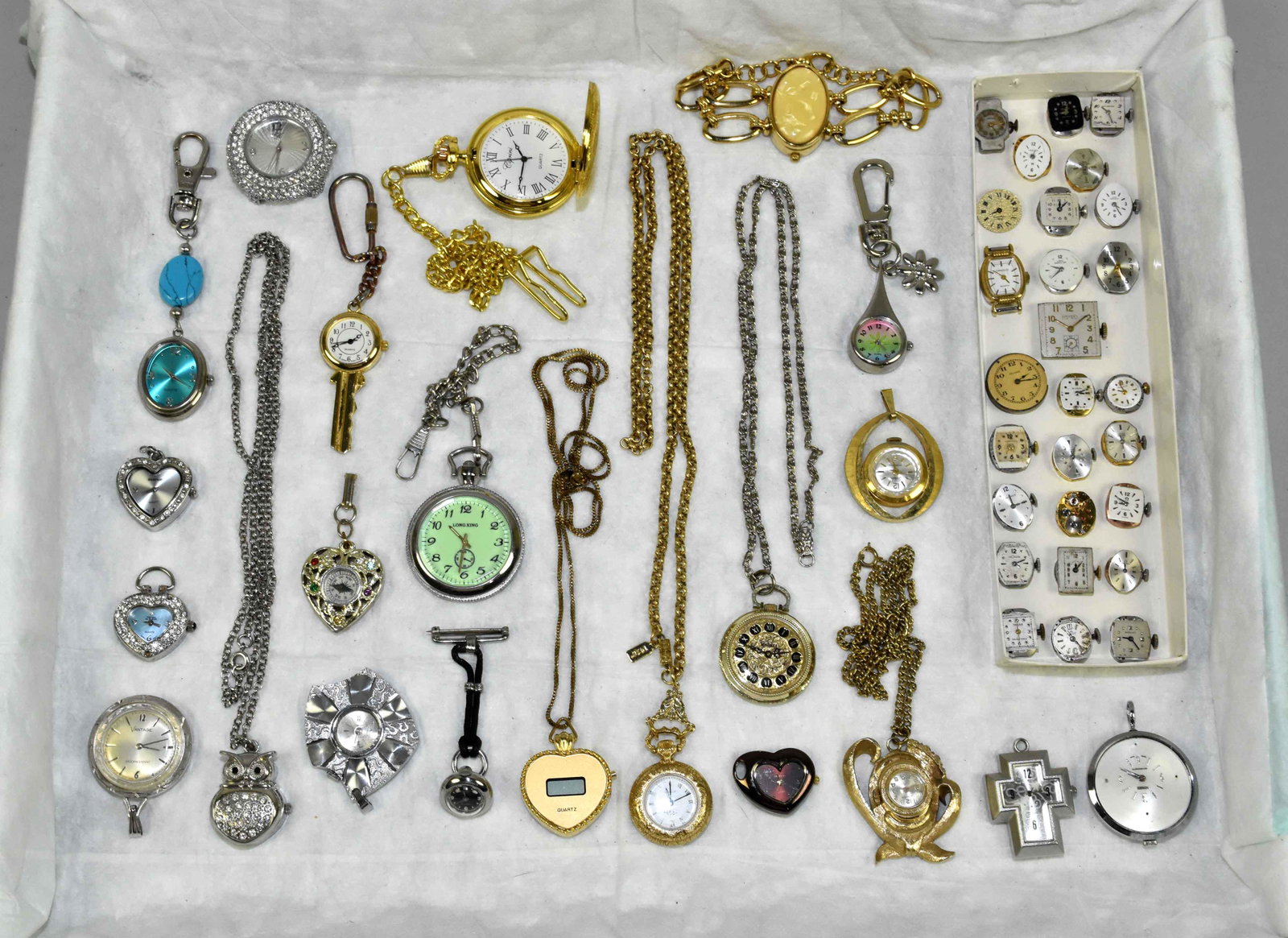 (35+) ASST. LADIES PENDANT AND LOCKET TIMEPIECES IN: (35+) ASST. LADIES PENDANT AND LOCKET TIMEPIECES IN GOLD AND SILVER TONES. Makers: Swiss, 1928, Webster, Geneva and others. With 20+ watch faces.