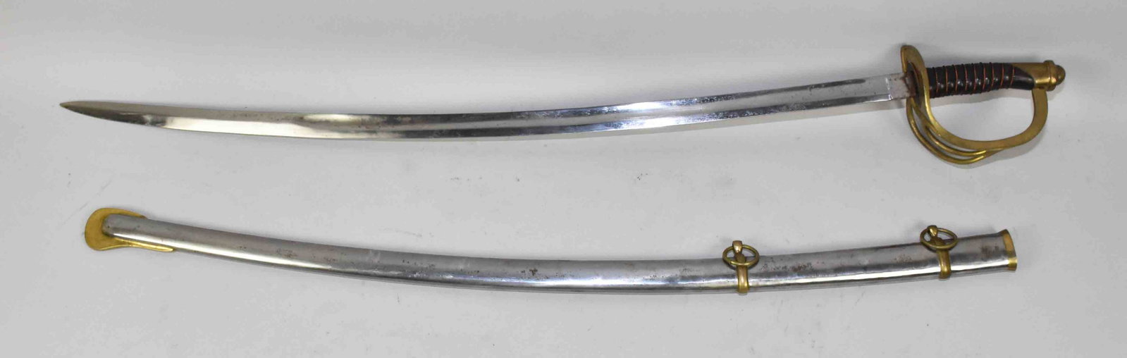 REPLICA U.S. MODEL 1840 HEAVY CAVALRY SABER - 34'': REPLICA U.S. MODEL 1840 HEAVY CAVALRY SABER - 34'' single fuller bright blade, unmarked at the ricasso. Three branch brass guard and pommel. Twisted copper wire-wrapped leather grip. Bright metal scab