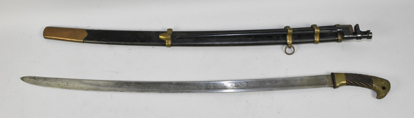 RUSSIAN COSSACK SABER & SOCKET BAYONET - Suite in: RUSSIAN COSSACK SABER & SOCKET BAYONET - Suite in scabbard. Saber with a 32'' slightly curved blade, rope carved wood grip with brass mounts. Ca. 1890.