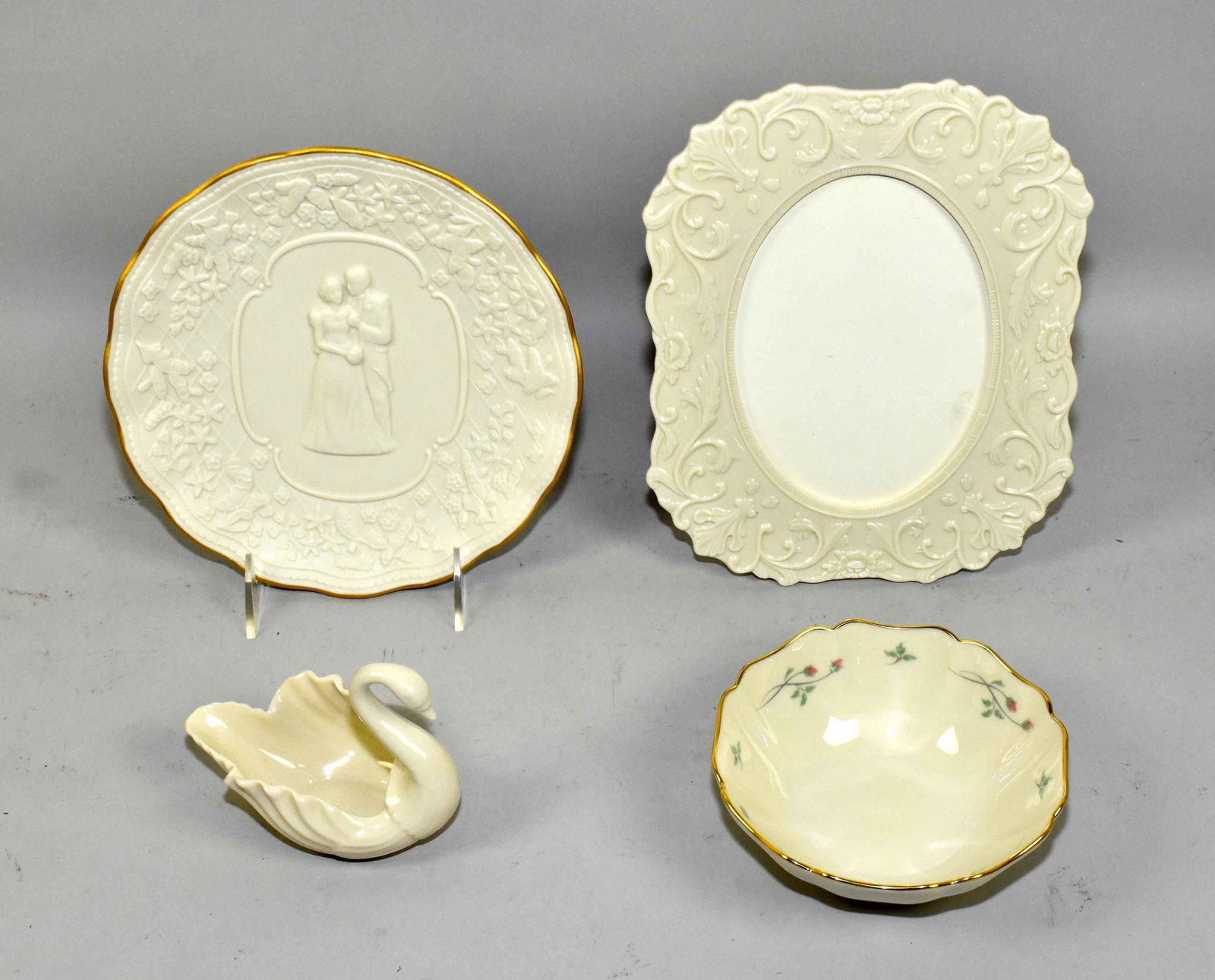 (4) ASST. IVORY LENOX PORCELAIN COLLECTOR ITEMS. To: (4) ASST. IVORY LENOX PORCELAIN COLLECTOR ITEMS. To include: picture frame 9.25''H, wedding plate, small floral bowl and a swan.