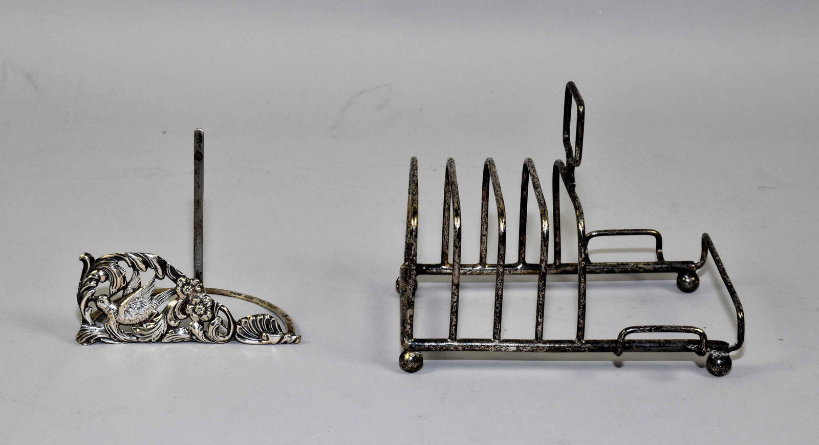 STERLING MENU HOLDER AND SILVER-PLATE TOAST RACK. And: STERLING MENU HOLDER AND SILVER-PLATE TOAST RACK. And edwardian Sterling menu holder, pierced with stylized birds and shells, 3 1/4 inches length; 3 inches high. And a five bar toast rack, 5 inch leng