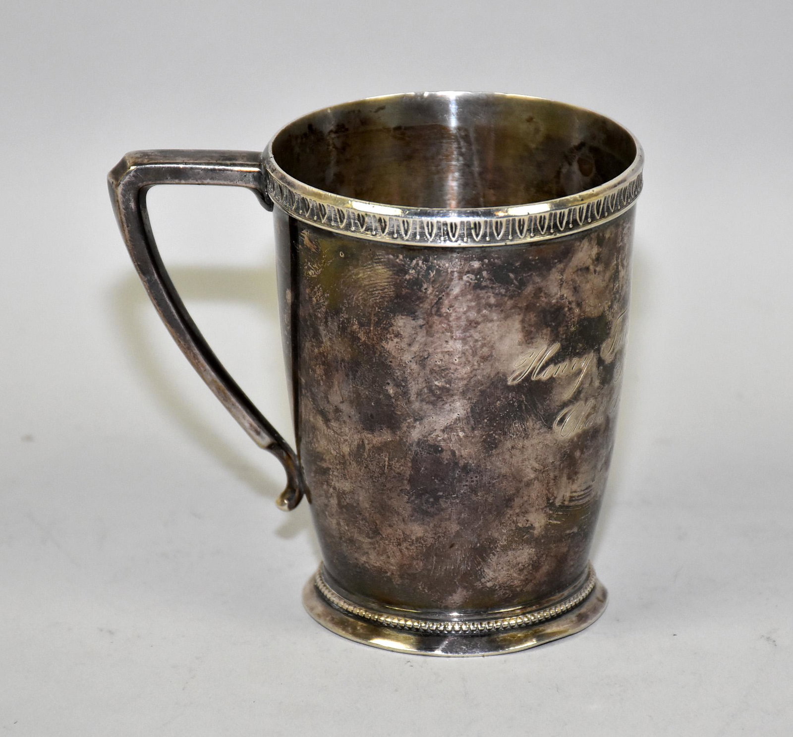 ANTIQUE COIN SILVER CUP. Engraved ''Henry Fairbanks: ANTIQUE COIN SILVER CUP. Engraved ''Henry Fairbanks Stevens from Cha.. F Fairbanks''. Condition: several small dents to base, small hole in bottom of handle, other minor dents. 3.75'' H. Total weight: