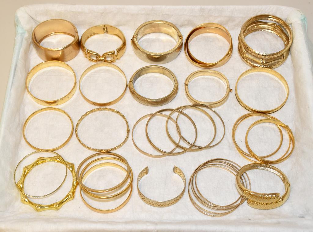 30 MISCELLANEOUS LADIES GOLD TONE FASHION BANGLES: 30 MISCELLANEOUS LADIES GOLD TONE FASHION BANGLES. Various styles and sizes. To include Monet, Trifari and Russell Karatclad.
