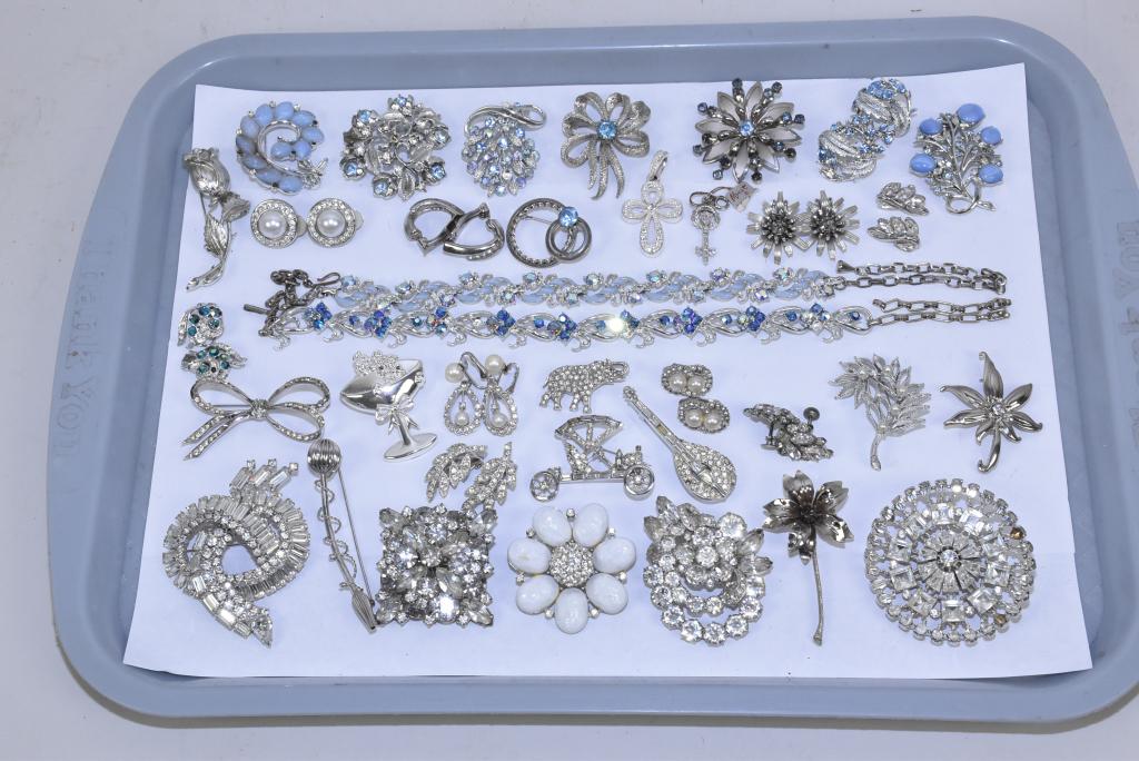 25 ASSORTED RHINESTONE COSTUME JEWELRY PIECES.: 25 ASSORTED RHINESTONE COSTUME JEWELRY PIECES. With white and blue stones in silver tone. To include brooches, necklaces, and clip pearl earrings. Signed pieces: Eisenberg, Pell, Coro, Lisner and Star