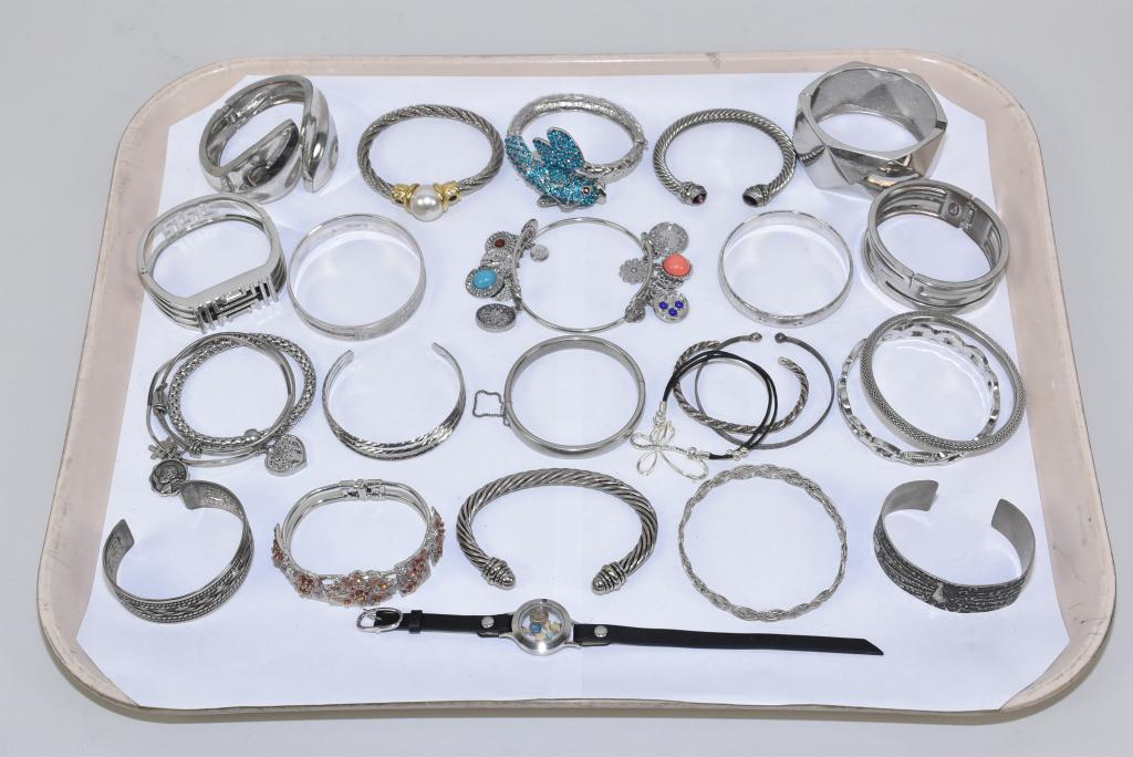 20+ ASSORTED SILVER TONE FASHION BRACELETS: 20+ ASSORTED SILVER TONE FASHION BRACELETS AND BANGLES. In a variety of styles.