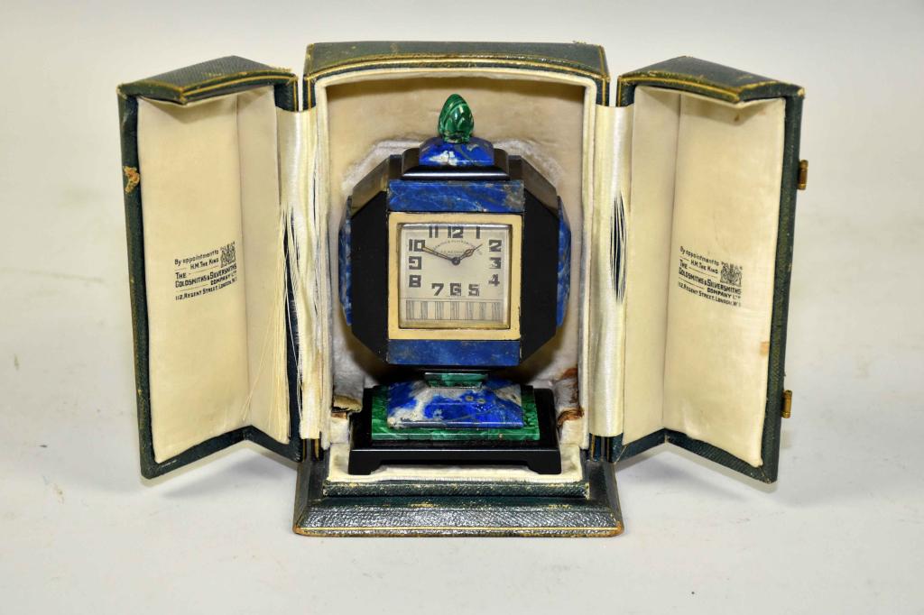 THE GOLDSMITHS AND SILVERSMITHS COMPANY, LONDON AR: THE GOLDSMITHS AND SILVERSMITHS COMPANY, LONDON ART DECO MINIATURE CLOCK. Silver onyx, malachite and lapis luzuli, 1932. Swiss movement by Geneva Clock Co. Includes key and original fitted box. Condit