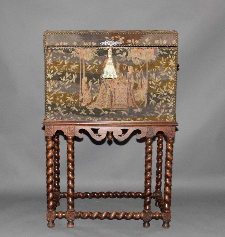 ANTIQUE TAPESTRY TRUNK/COFFER, on wooden table sta: ANTIQUE TAPESTRY TRUNK/COFFER, on wooden table stand. Trunk - 23''H x 33''W x 18''D. Table stand - 30''H x 32''W x 22.5''D.