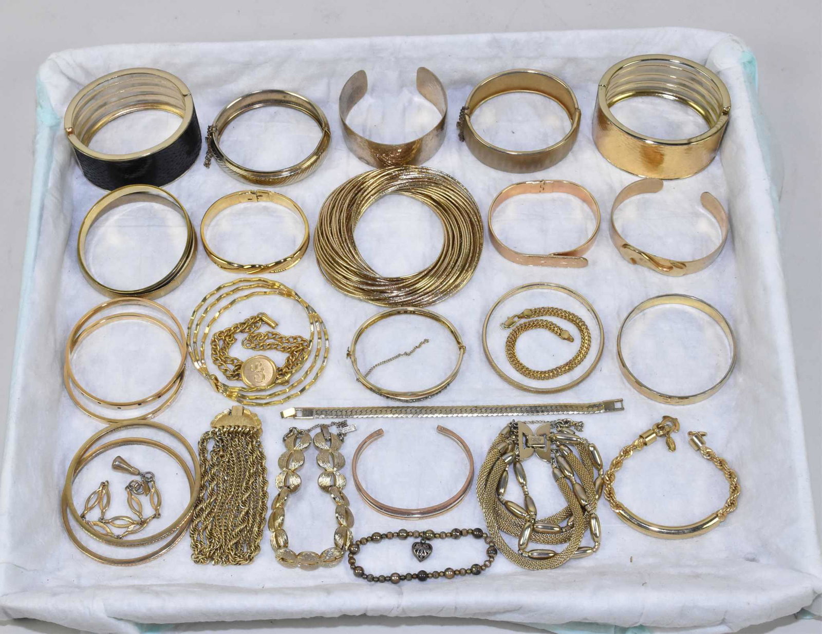 25 MISCELLANEOUS GOLDTONE FASHION BRACELETS: 25 MISCELLANEOUS GOLDTONE FASHION BRACELETS. To include 2 Swarovski bangles, assorted Monet and a Beeline.