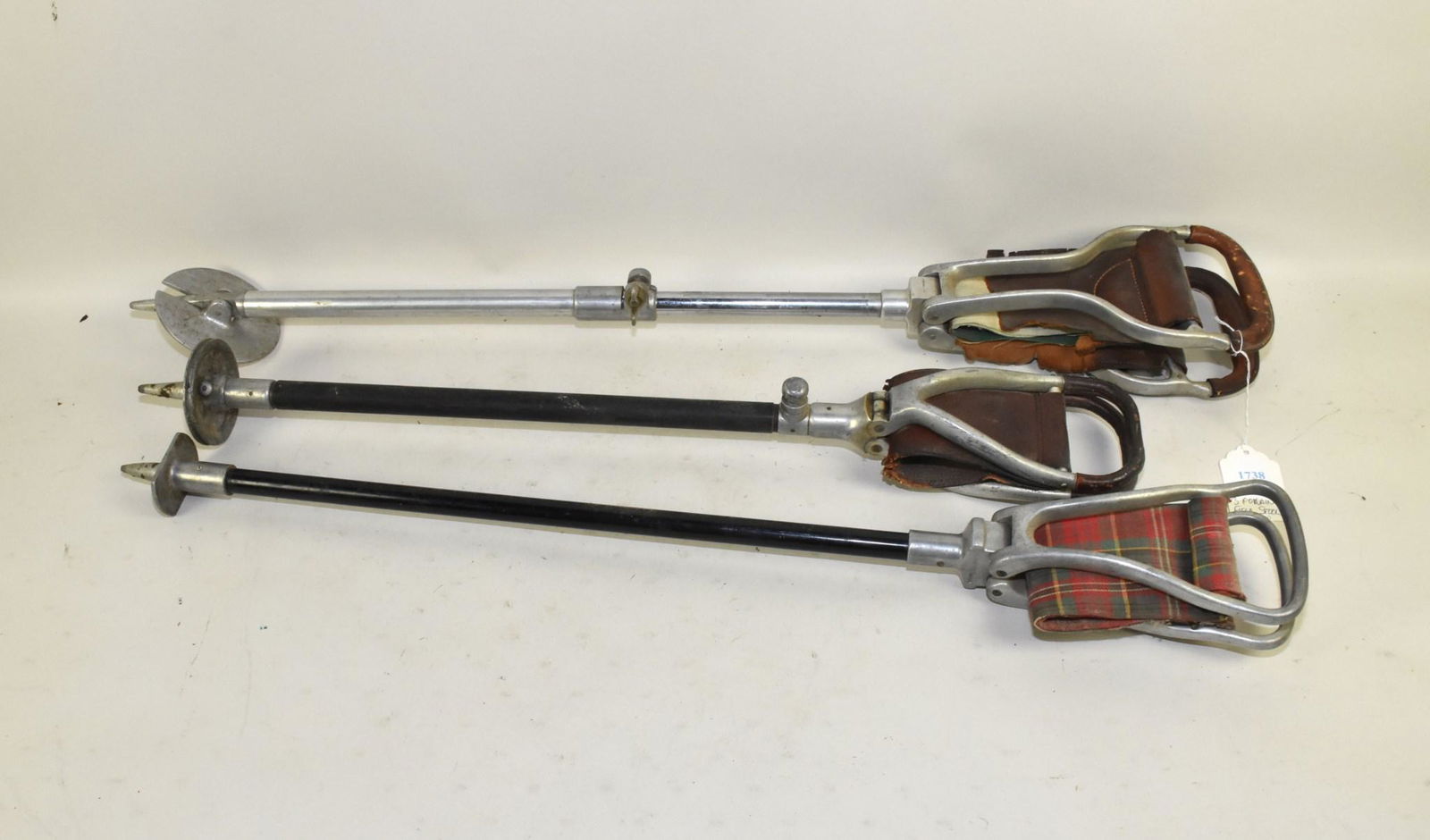 ADJUSTABLE LEATHER SEAT SHOOTING STICKS - Three.: ADJUSTABLE LEATHER SEAT SHOOTING STICKS - Three. Aluminum, wood and leather with folding seat/handle. Note: Some dryness to the leather.