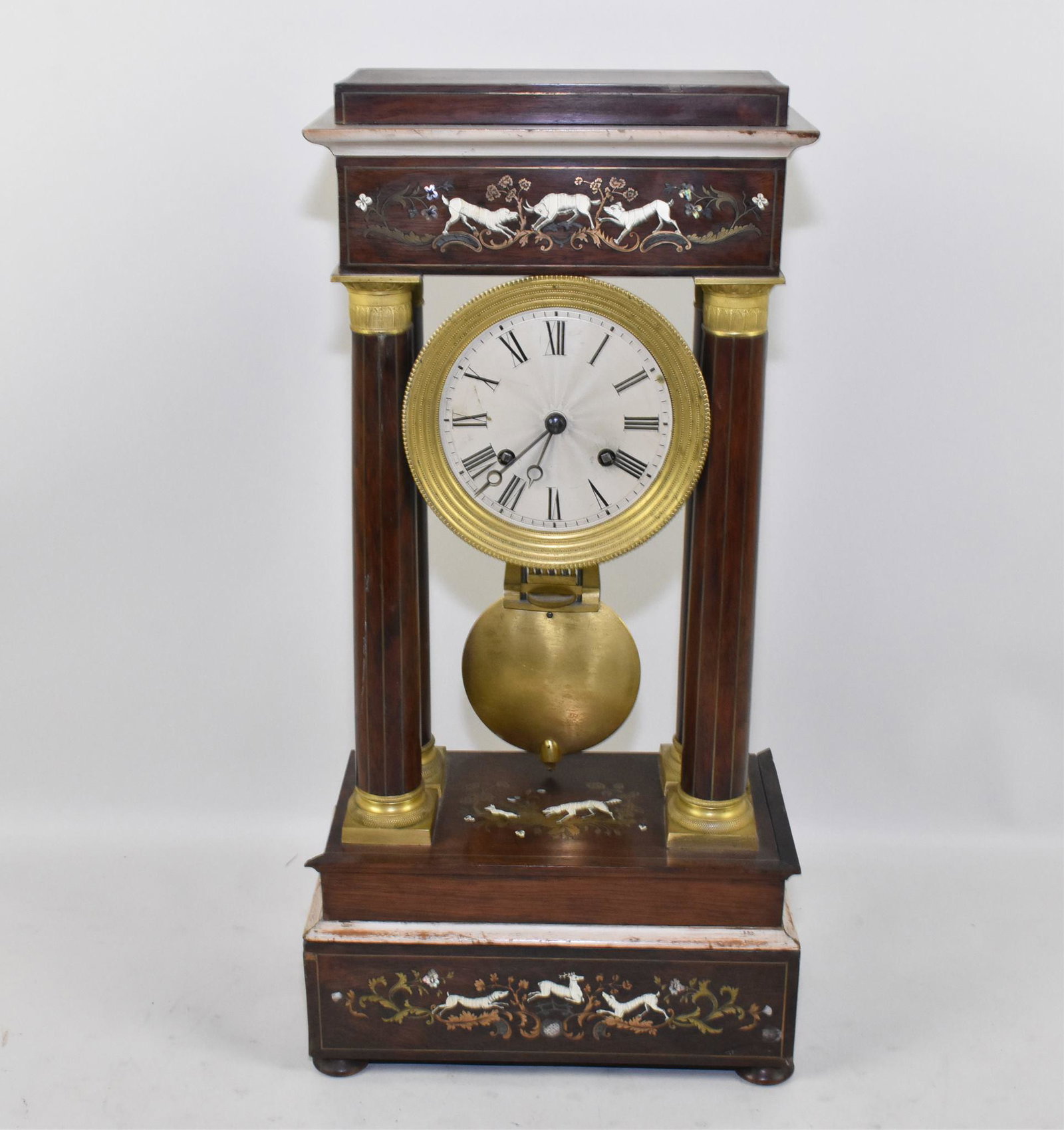 FRENCH INLAID PILLAR CLOCK - Mid 19th century: FRENCH INLAID PILLAR CLOCK - Mid 19th century. Open column design with engraved brass and bone inlays of stags with hounds in pursuit. 21" high x 10.25" wide. Bronze, mahogany with engraved brass, bon