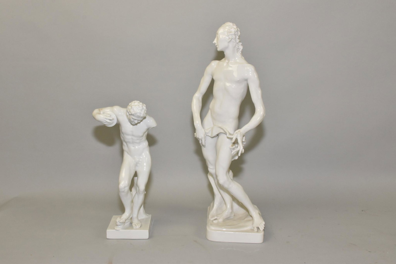 PORCELAIN CLASSICAL SCULPTURES - Two.: PORCELAIN CLASSICAL SCULPTURES - Two. Reproductions of originals. Discobolus with a missing arm by Capo-di-Monte and a tall nude gentleman with an underglaze blue mark. The tallest: 15".