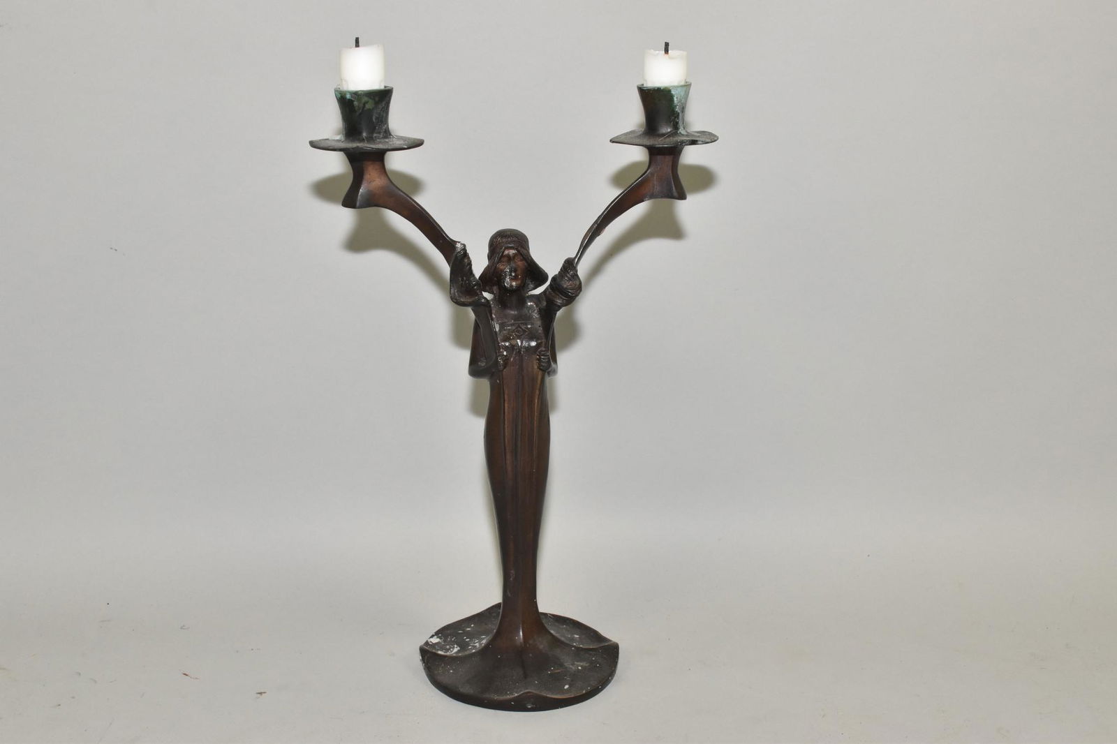 ART DECO TWO-LIGHT FIGURAL CANDLESTICK: ART DECO TWO-LIGHT FIGURAL CANDLESTICK - Patinated bronze figure of a graceful female form supporting two tall candle sockets. 13" h. Dark patina.