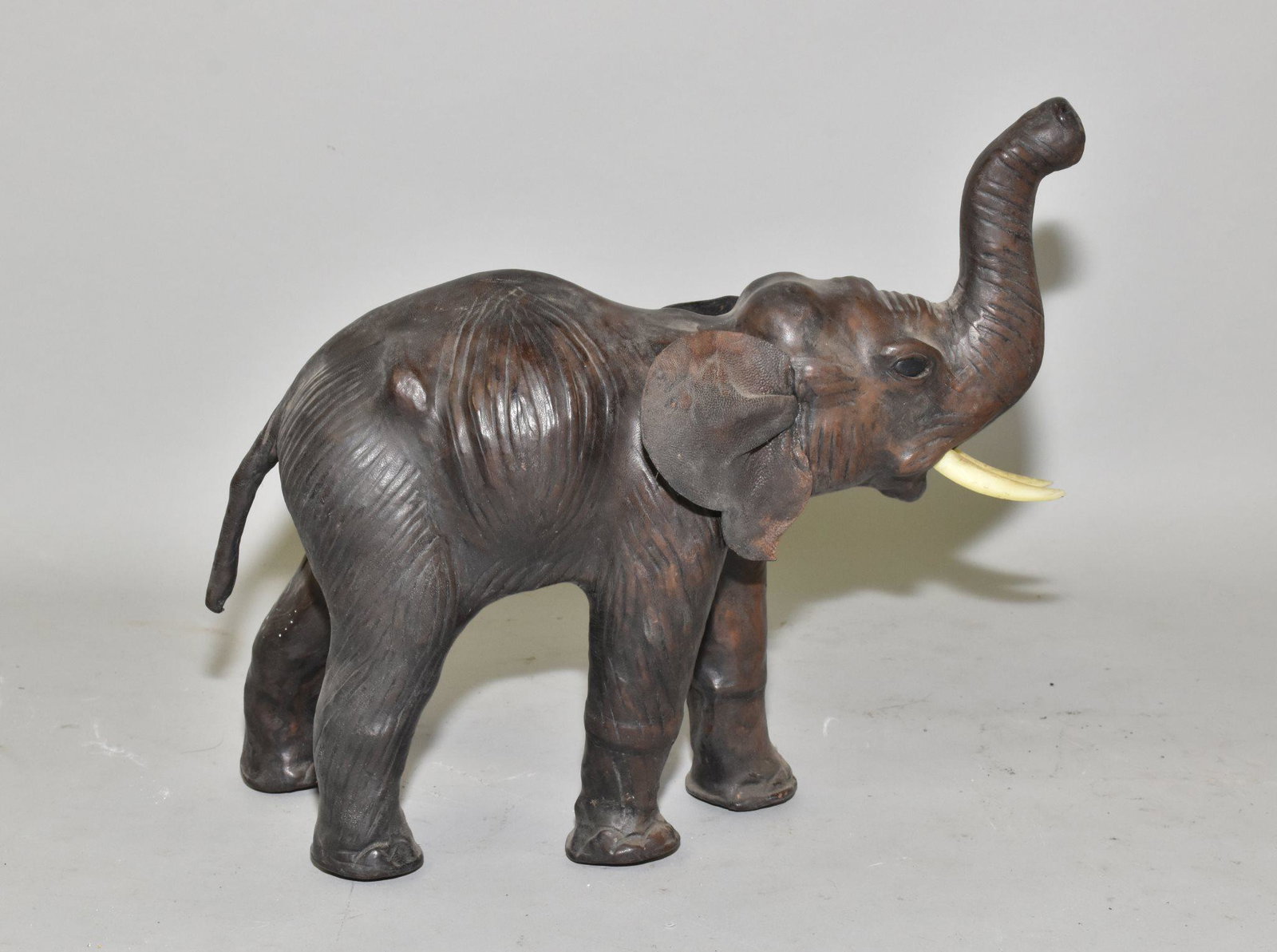 ELEPHANT WITH UPRAISED TRUNK - Asiatic wood: ELEPHANT WITH UPRAISED TRUNK - Asiatic wood carving, ivory composition tusks, leather ears. 11" h. at trunk x 14" long.