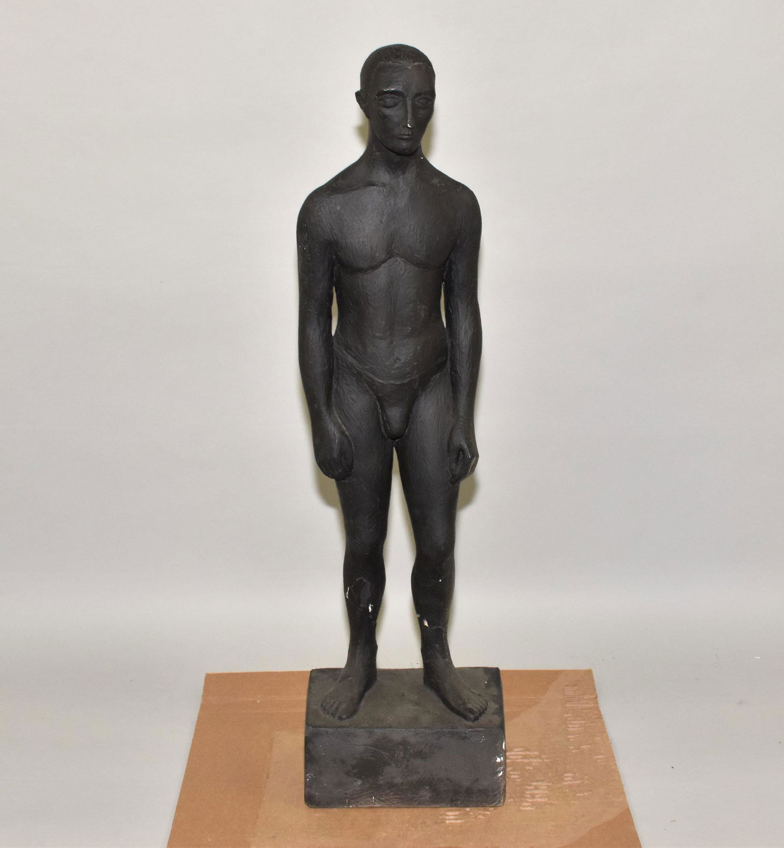 PLASTER/CHALKWARE FULL FIGURE OF A NUDE MALE: PLASTER/CHALKWARE FULL FIGURE OF A NUDE MALE - Standing upon a square base. Overall painted black. 30" h. African/ American. Signed on under side of base: Sister ___ . Partially defaced.
