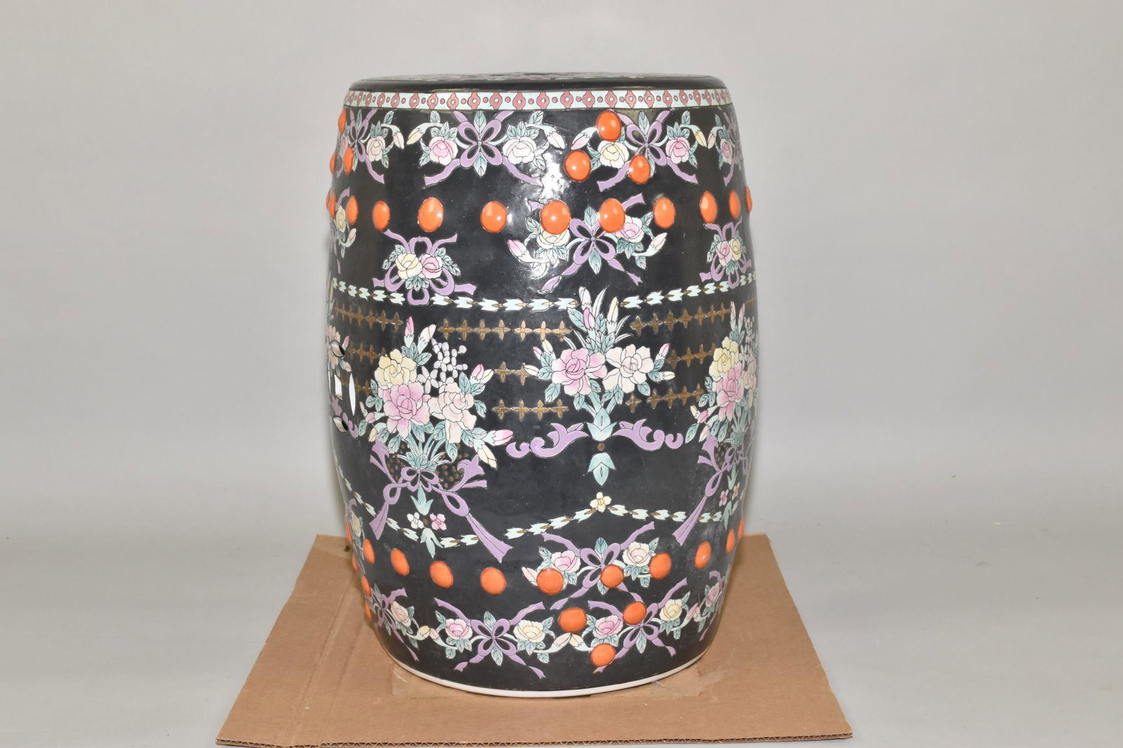 CHINESE POTTERY GARDEN SEAT - Barrel form with: CHINESE POTTERY GARDEN SEAT - Barrel form with decoratively pierced top. The ground is painted black with flower sprays and oranges in the decor. 18" h. x 12" top diameter.