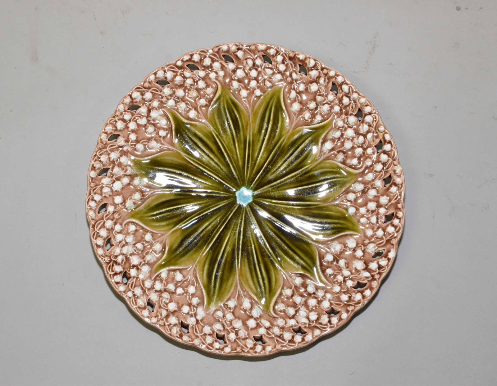ANTIQUE MAJOLICA WALL PLATTER: CIRCA 1891-1912: ANTIQUE MAJOLICA WALL PLATTER: CIRCA 1891-1912. VILLEROY & BOCH, GERMANY. LILLY OF THE VALLEY PATTERN 1132 WHITE BELL FLOWERS ON MOCHA BACKGROUND. AGE APPROPRIATE WEAR. 12" DIAMETER.