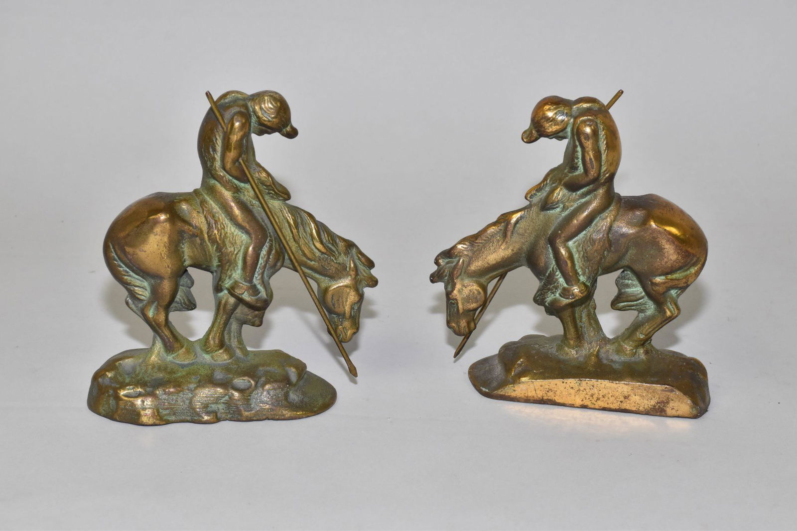 ANTIQUE BRONZE PATINATED CAST IRON BOOKENDS: ANTIQUE BRONZE PATINATED CAST IRON BOOKENDS: "END OF THE TRAIL" NATIVE INDIAN ON HORSEBACK WITH LANCE. CIRCA 1920. 6 INCHES HIGH 5 1/2 INCHES WIDE 2 INCHES DEEP.