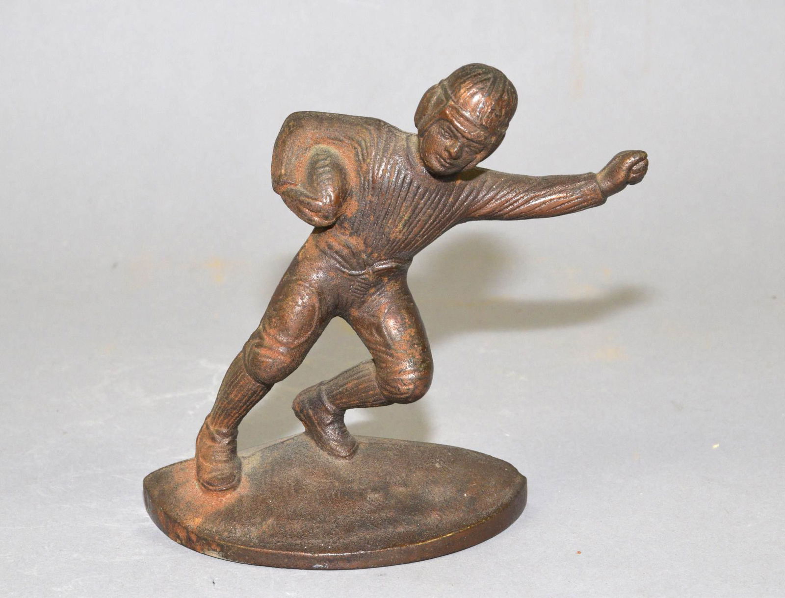 ANTIQUE FOOTBALL PLAYER CAST IRON BOOKEND: ANTIQUE FOOTBALL PLAYER CAST IRON BOOKEND. (ONE ONLY). 5.5 INCHES HIGH.